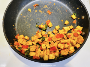 Tofu in pan with all other ingredients (tomatoes, spinach, spices).